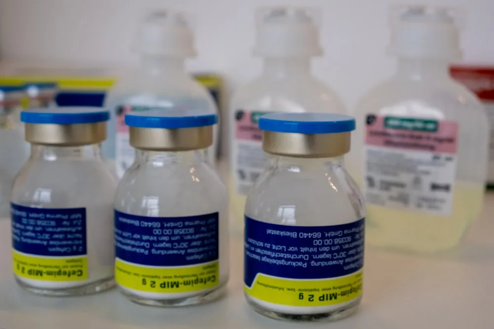 Medical vials and bottles on a pharmacy shelf