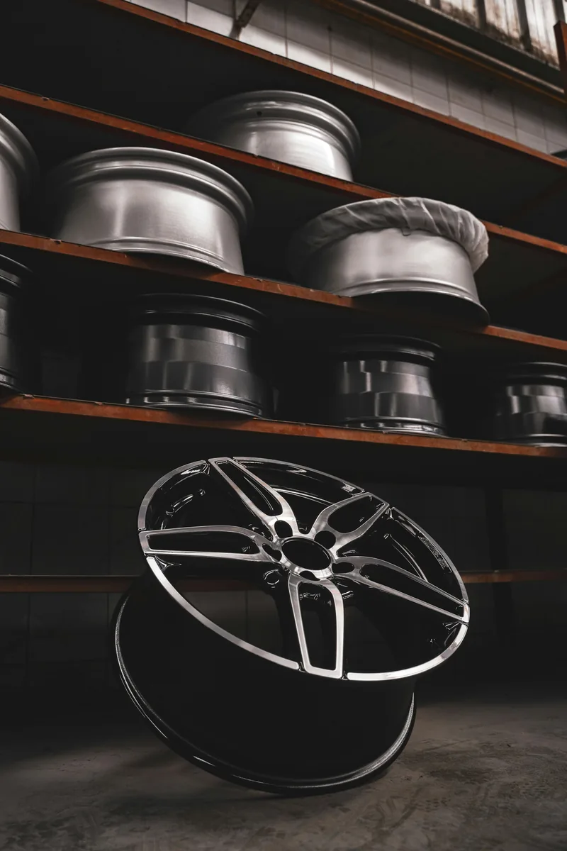 Alloy wheel rim in front of warehouse shelves stocked with rims
