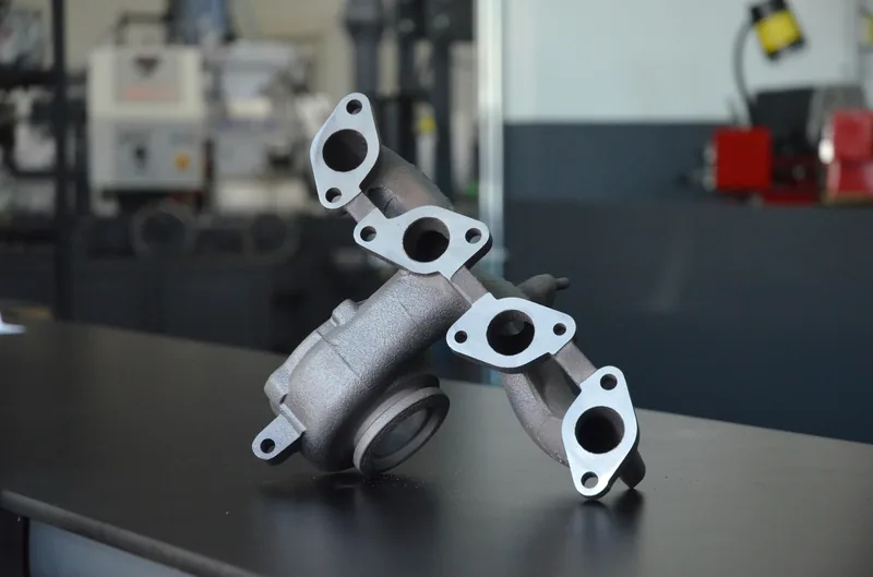 Cast aluminum exhaust manifold on a workshop bench