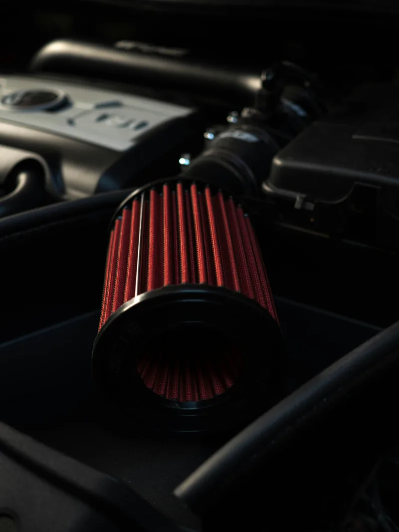 Performance cone air intake filter installed in an engine bay